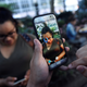 A Pokemon appears on the screen next to a woman in the augmented reality mobile game “Pokemon Go” in Bryant Park.